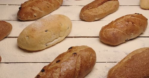A Large Selection Of Different Breads Are Laid Out On The Table