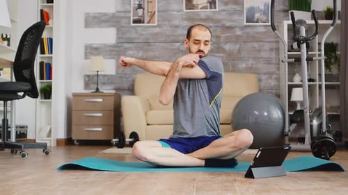 Man Doing Yoga at Home with Tablet
