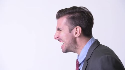 Head Shot Profile View of Young Angry Hispanic Businessman Screaming
