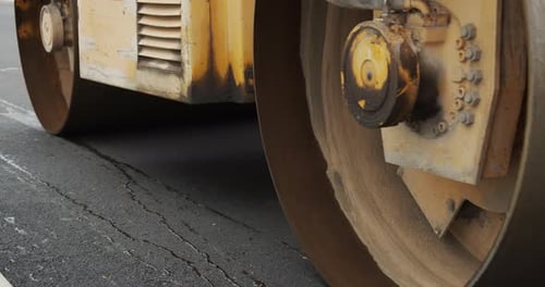 A Large Yellow Steamroller Flatten Hot Asphalt. Builds A New Road