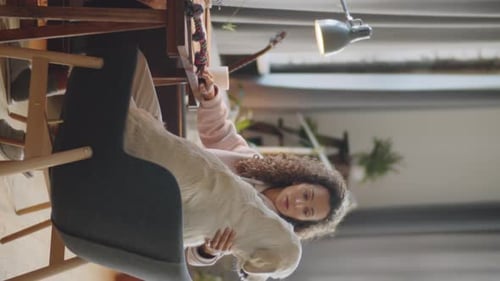 Woman Working at Desk with Dog in Lap