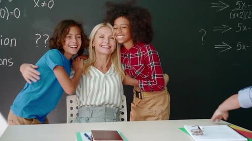 Teacher and Students Embracing in Classroom