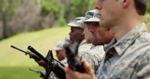 People in Camouflage with Rifles Outdoors