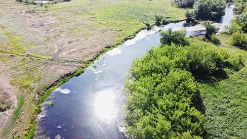 The Sun Is Reflected in the River. Aerial View. The Green Trees Near the River. The Water Surface of