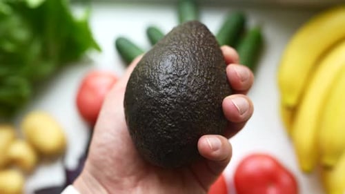 Male Hand Holds an Avocado The Concept of Proper Nutrition