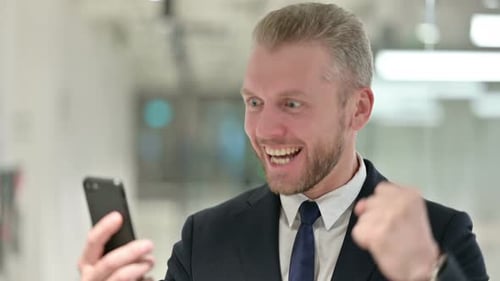 Man Reacts Positively To His Phone In An Office