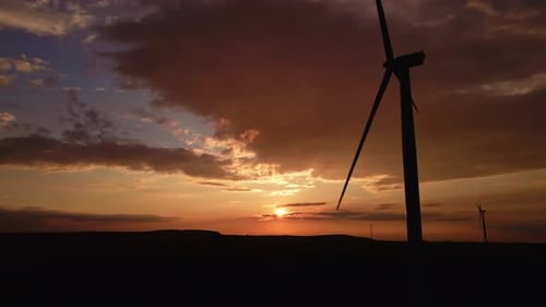 Silhouette of Windmill Turbine in Field at Sunset Sky