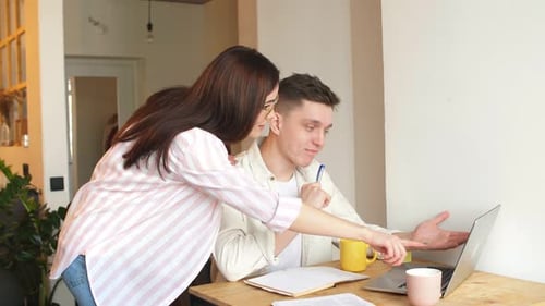 Young Adults Collaborating on Laptop at Home