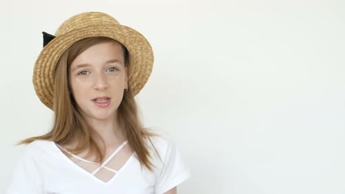Young Girl Talking Wearing a Straw Hat