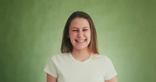 Attractive Model Laughs Happily Posing for Camera on Green