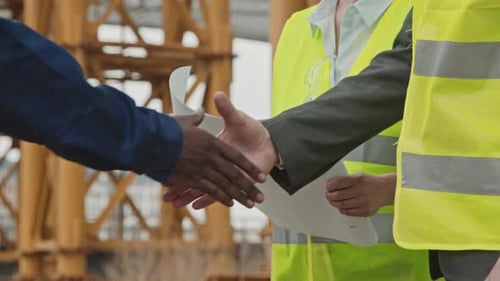 Trabalhadores irreconhecíveis de canteiros de obras apertando as mãos