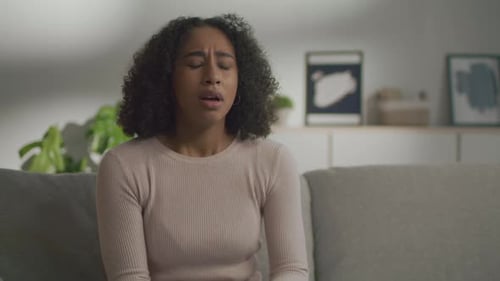 Young Woman Coughing from a Cold on Couch