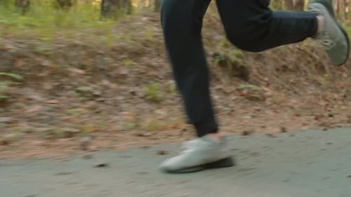 Legs of Man Running in Park