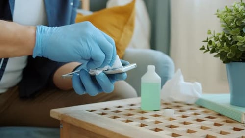 Close-up of Man's Hands Wet Wiping Gadget Modern Smartphone with Sanitizer During Epidemic