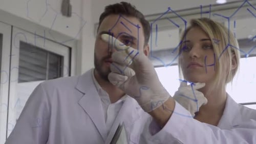 Scientists Drawing Molecular Structures on Glass Board