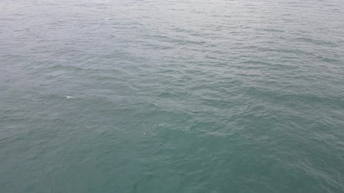 Top down aerial view of giant ocean waves crashing and foaming