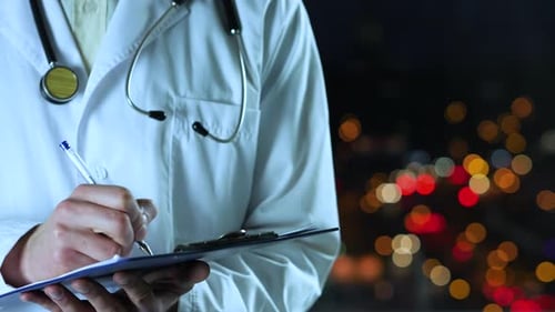 Doctor Taking Notes at Night in City Office