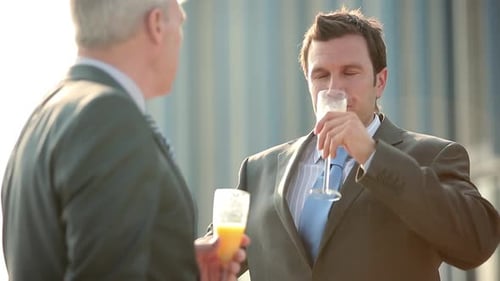 Businessmen Toasting with Orange Juice Outside