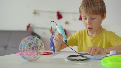 Close Up Shot of a Little Boy That is Using a 3d Pen