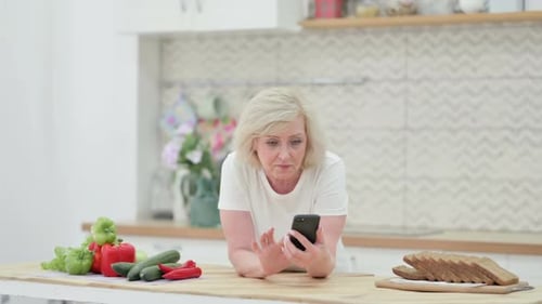 Blonde Woman Using Phone in Bright Kitchen