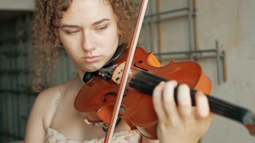 Focused Young Woman Playing Violin with Skill