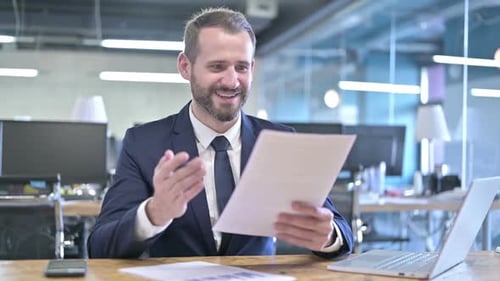 Excited Man Reads Good News in Office