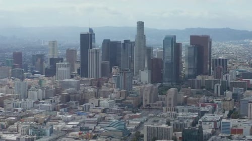 AERIAL: Slowly Circling Downtown Los Angeles Skyline with Warehouse Art District in Foreground with