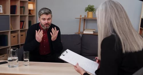 Crop View of Emotional Man Sitting and Having Therapy Session with Female Person