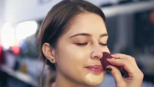 Makeup Artist Applies Foundation to Woman's Face