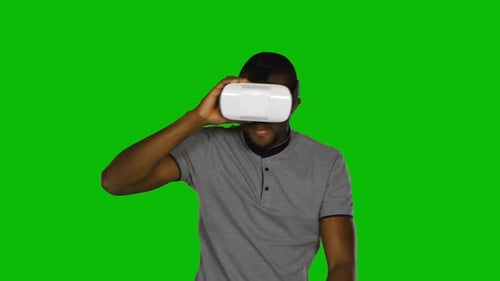 Man Holds a Mask of Virtual Reality on His Head. Green Screen