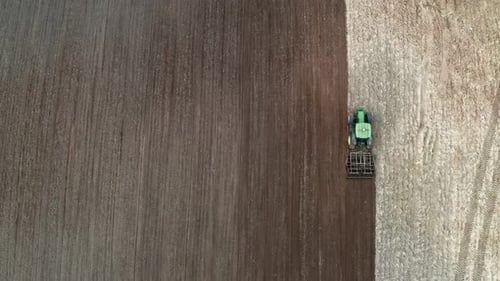 Tractor working on spring field, aerial view