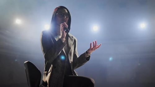 Woman Giving Speech or Presentation on Stage