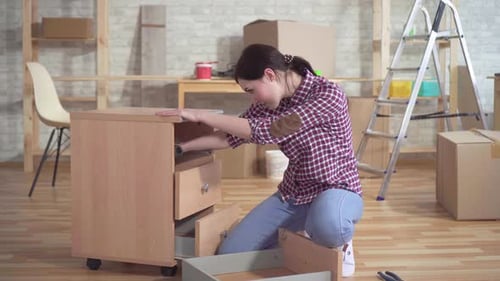 Jeune femme engagée dans l'assemblage de la table de chevet