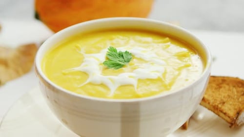Kürbissuppe in Schüssel serviert mit Brot