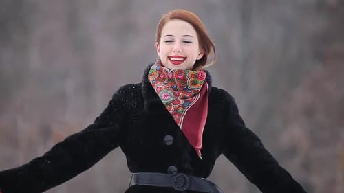 Beautiful redhead woman in the winter park.