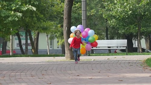 Joyful Child Runs with Balloons in Park