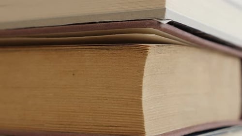 Vintage books pile darkened with shelf dust close-up 4K 2160p 30fps UltraHD tilting footage - Stack
