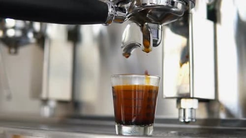 Espresso Pouring into Clear Glass Cup Close Up