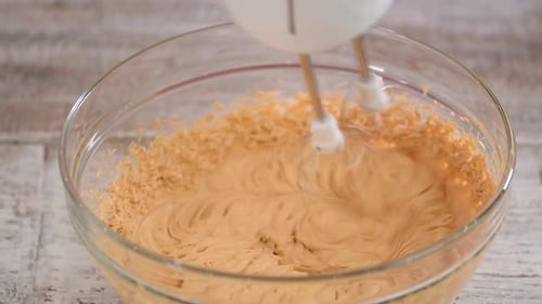 Electric Mixer Blending Creamy Mixture in a Glass Bowl