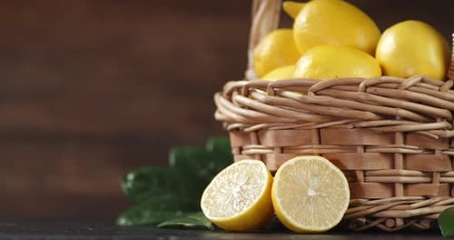 Frische Zitronen im Korb mit langsam rotierenden Blättern.