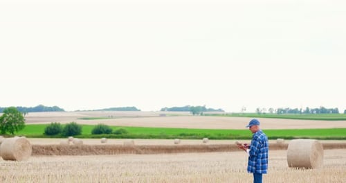 Farmer Using Digital Tablet While Examining Field