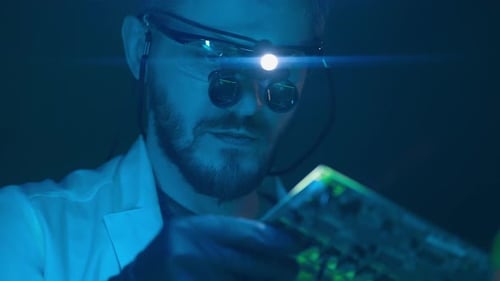 Scientist Inspecting Circuit Board in Dark Laboratory
