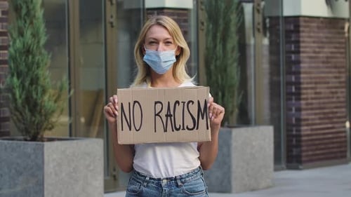 Woman Holds Sign Against Racism Outdoors
