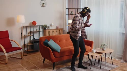 Young Man Dancing at Home with Headphones