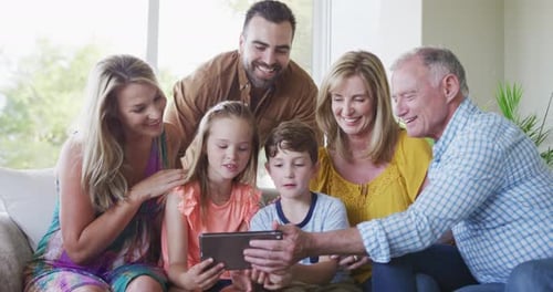 Family Smiling Together While Looking at a Tablet
