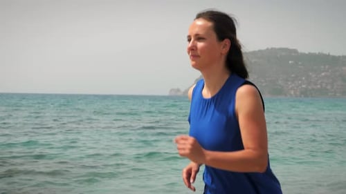 Woman running on beach at summer sunny day.