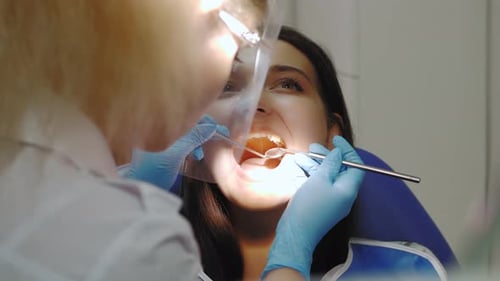 Dentist Examining a Patient's Teeth in the Dentist Office
