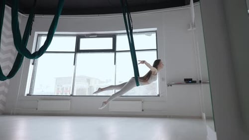 Woman Practicing Aerial Yoga in Fitness Studio