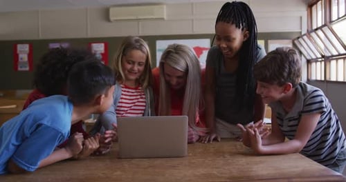 Female teacher and Group of kids using laptop in the class