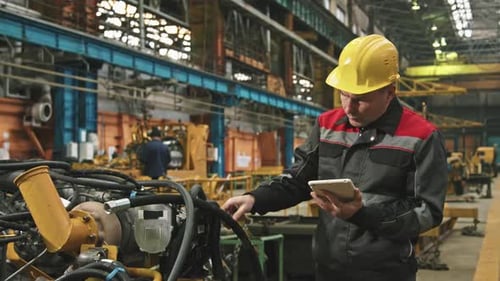 Plant Engineer Inspecting Machinery In Assembly Shop